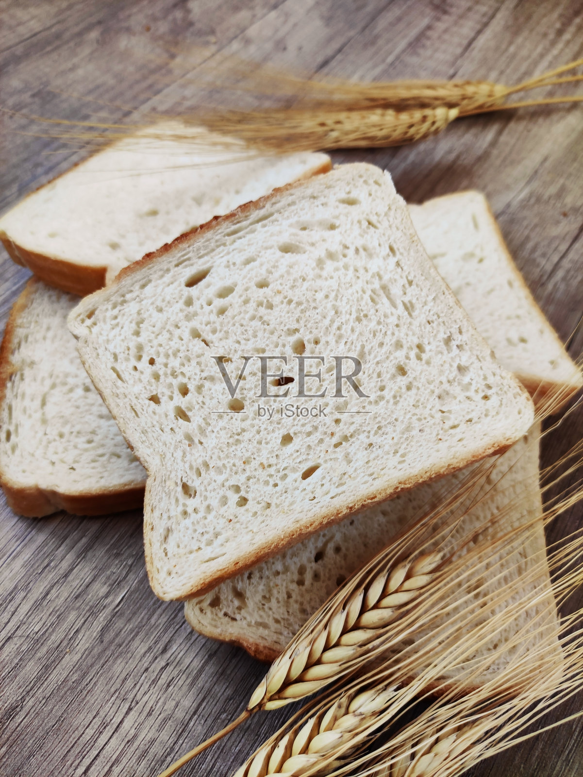 方形的白吐司面包块和干麦穗照片摄影图片