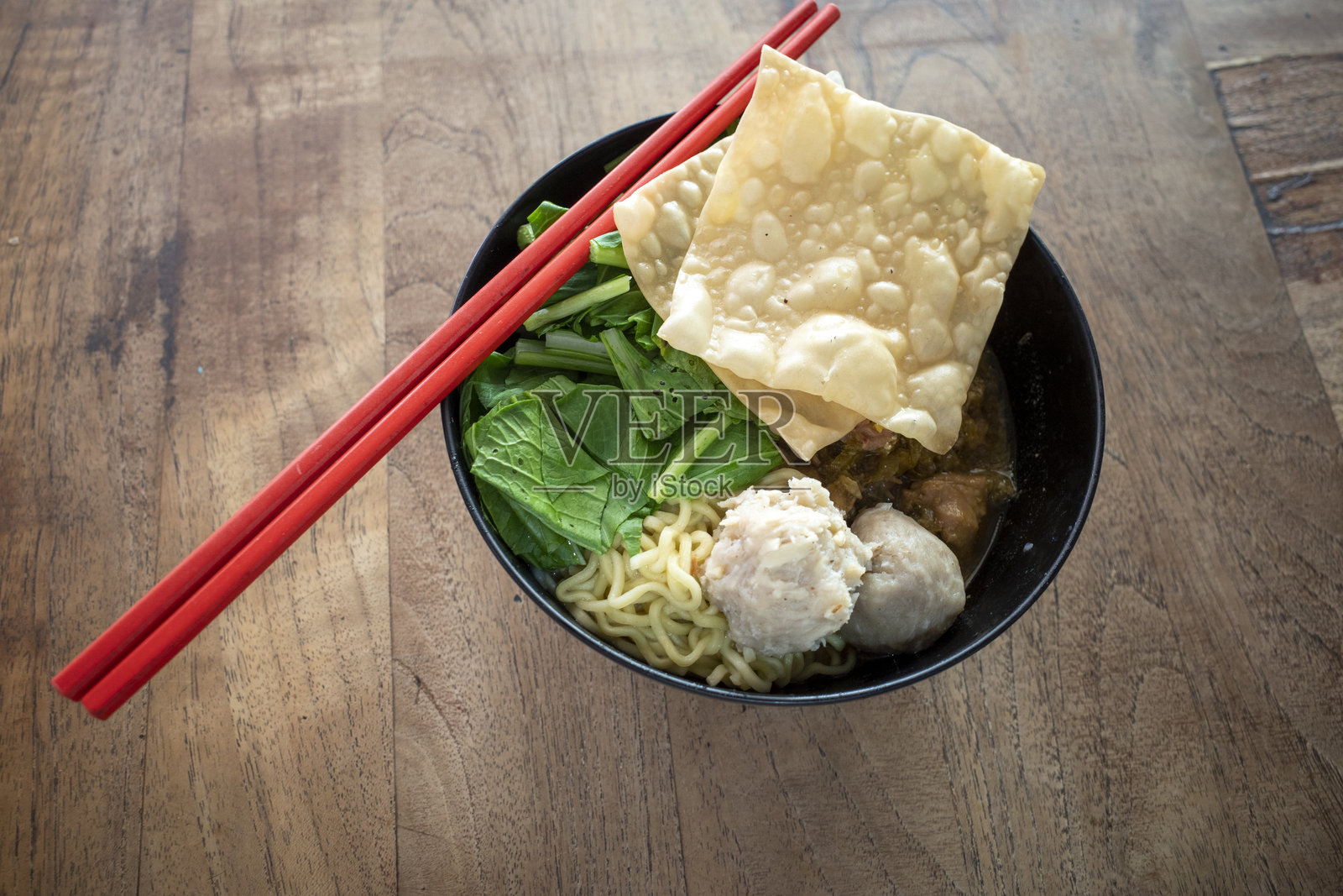 米粉肉丸汤，配有新鲜蔬菜和红色筷子，放在旧木桌上照片摄影图片