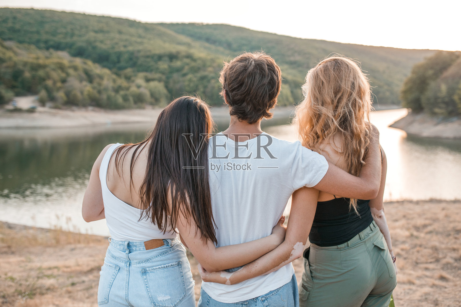 一小群最好的朋友从湖边拥抱并享受美景的背影照片摄影图片