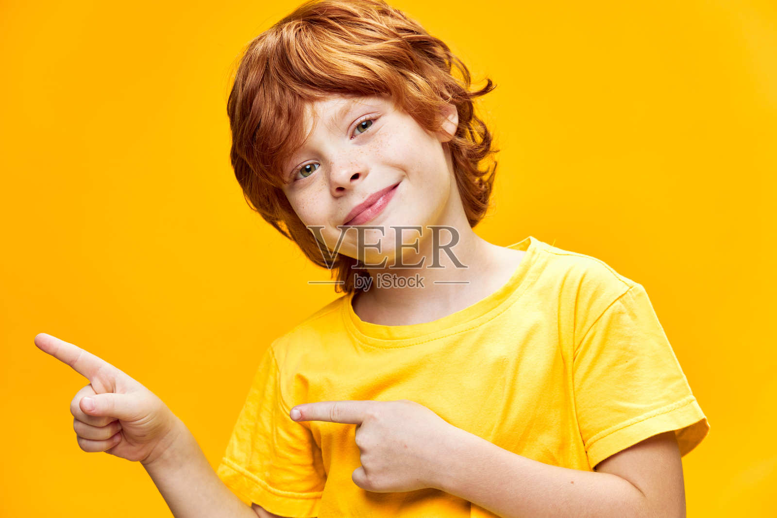 穿着黄色T恤的搞笑红发男孩正面视图，留白空间照片摄影图片