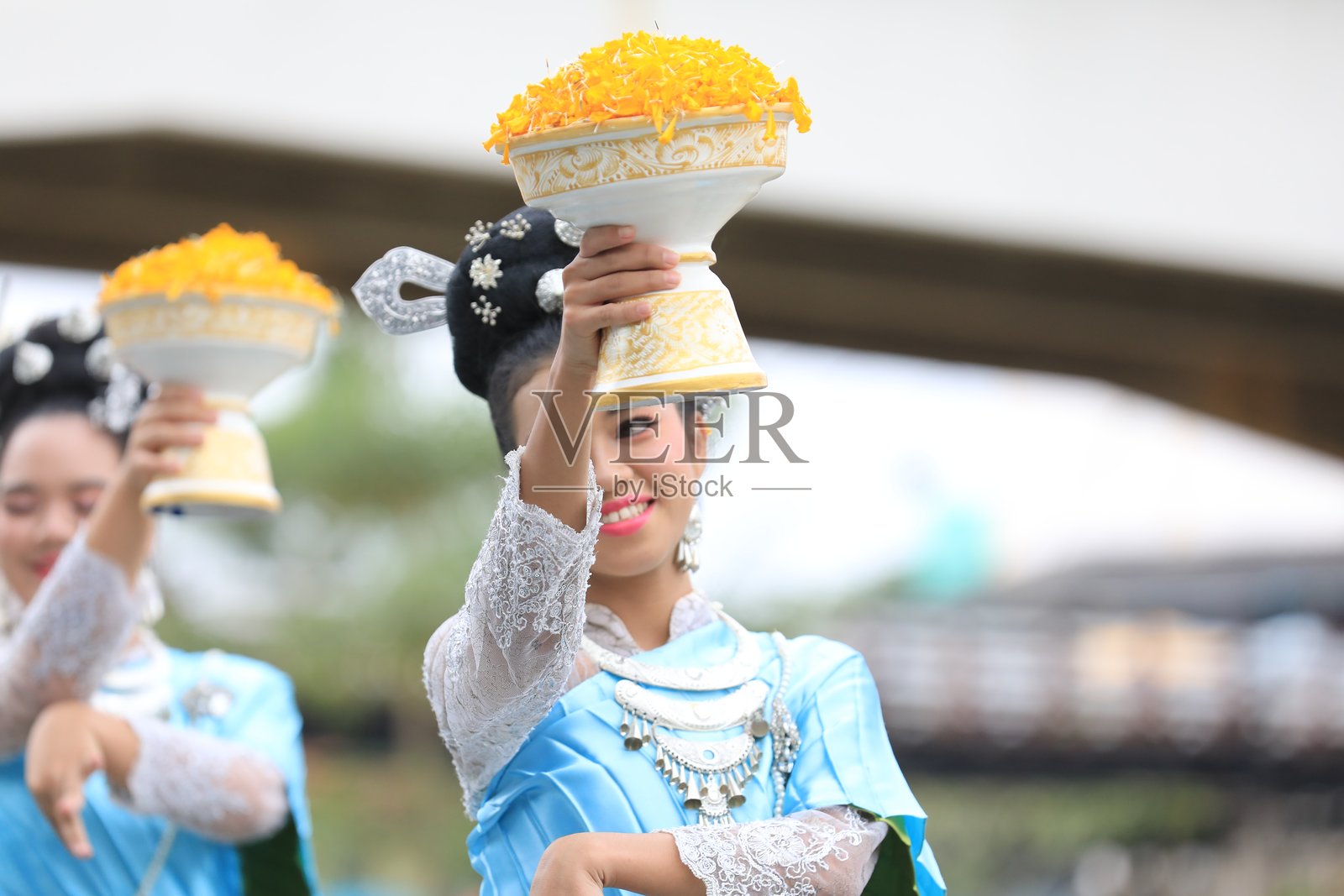 一群穿着传统泰国服装的亚洲男女在Ngao桥的献花节上跳舞。照片摄影图片