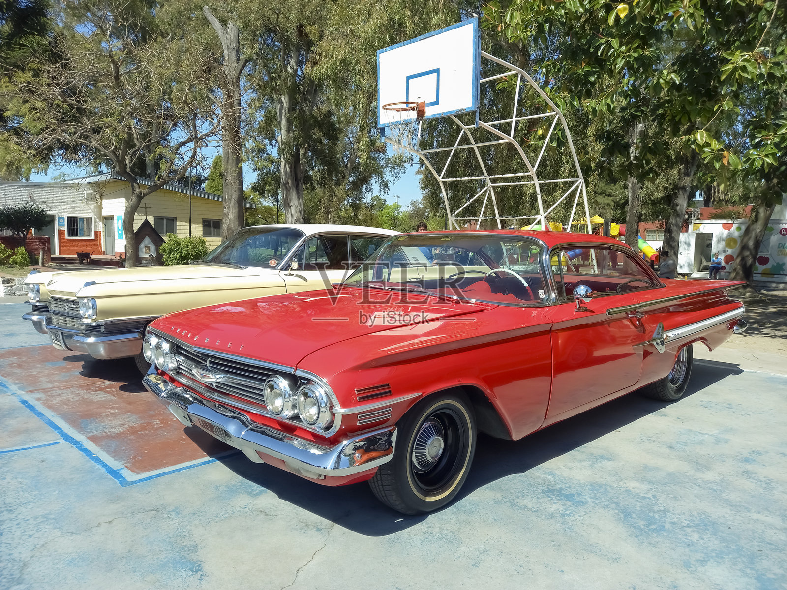 1960年红色闪亮的雪佛兰Impala运动轿跑在公园的经典车展上。照片摄影图片