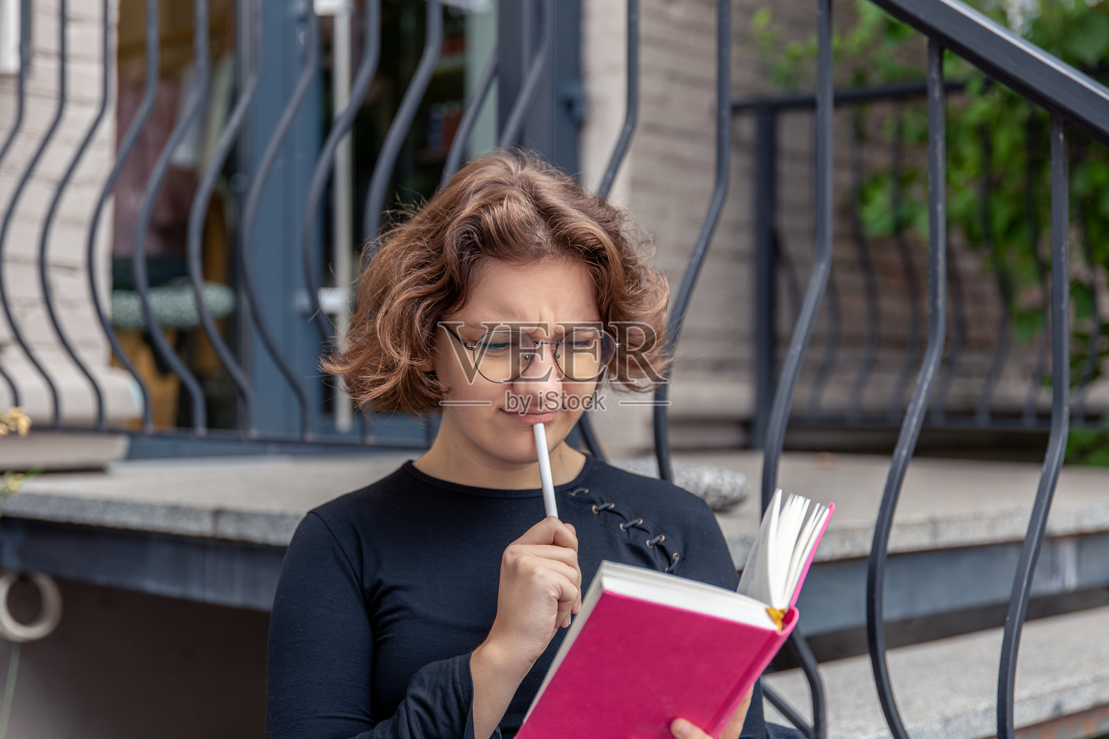 沉思的年轻女性在阅读一本书。情感概念。照片摄影图片