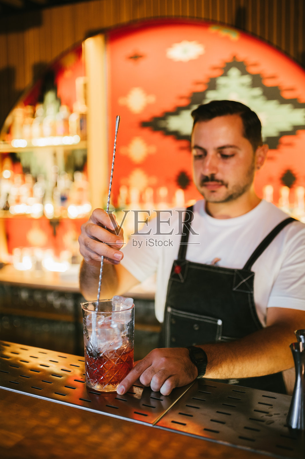 男性调酒师在鸡尾酒吧倒鸡尾酒照片摄影图片