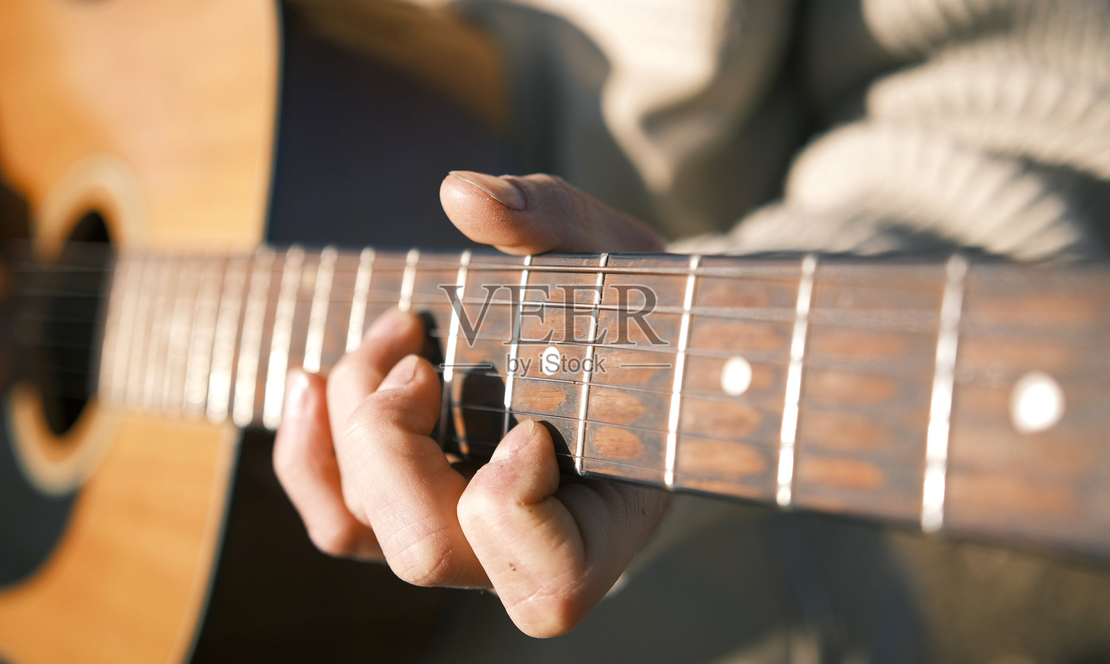 特写镜头下的男人弹吉他，聚焦于手、琴弦和吉他颈部。古典吉他课程。该图像传达出放松和享受的感觉。照片摄影图片