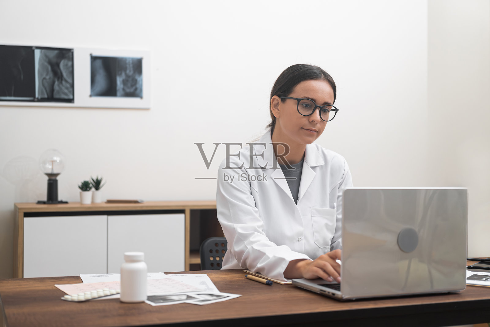 女医生，使用笔记本电脑，提供在线医疗服务，进行视频会议，照片摄影图片