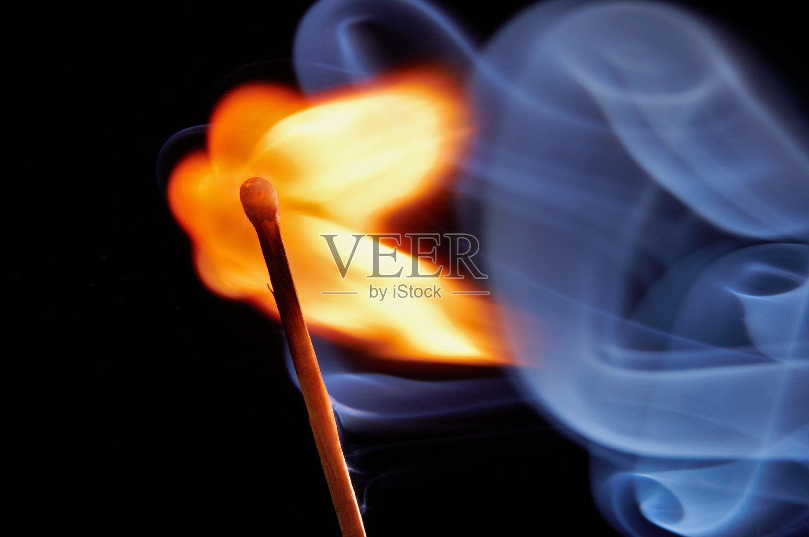 燃烧的火柴棒，鲜艳的火焰和烟雾在黑暗背景下，特写视角，动态运动，抽象构图，生动的光线对比照片摄影图片