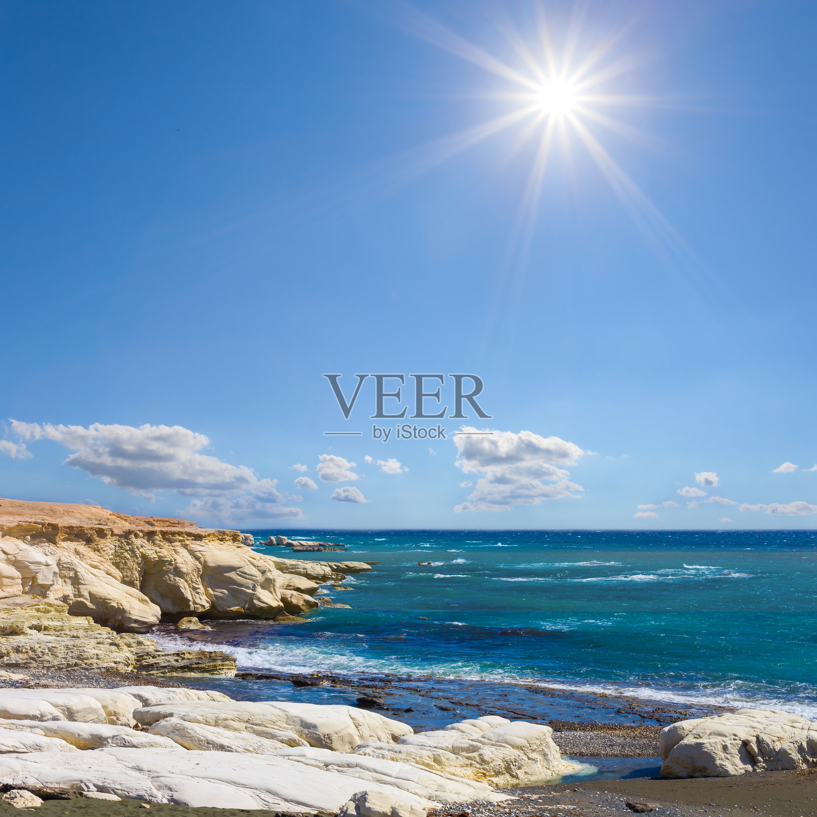 阳光明媚的日子里，碧绿海湾与石质海岸照片摄影图片