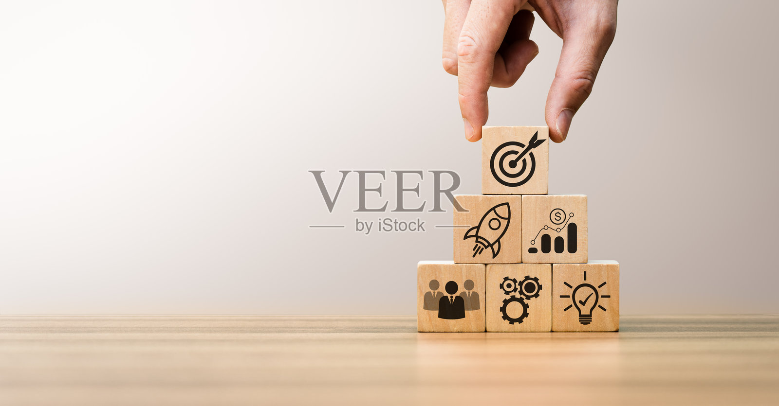 手工排列木块，上面有象征创业增长、团队合作、财务成功和目标达成的商业图标，代表构建成功创新商业战略的步骤。照片摄影图片