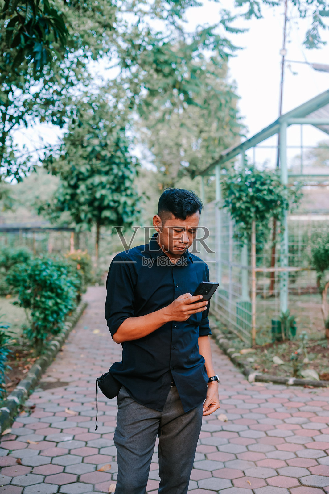 东南亚男子面带轻松表情，手握衬衫口袋。照片摄影图片