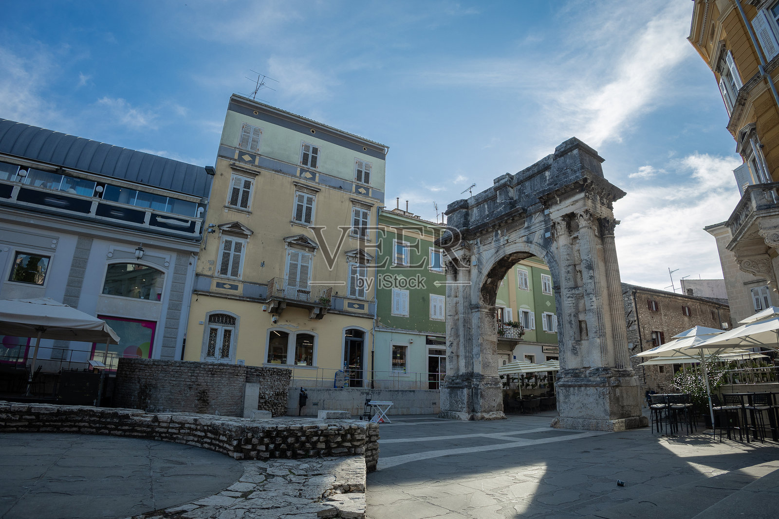 克罗地亚普拉的古老罗马城门。宏伟的古老城市入口或拱门位于市广场，周围有其他房屋。照片摄影图片