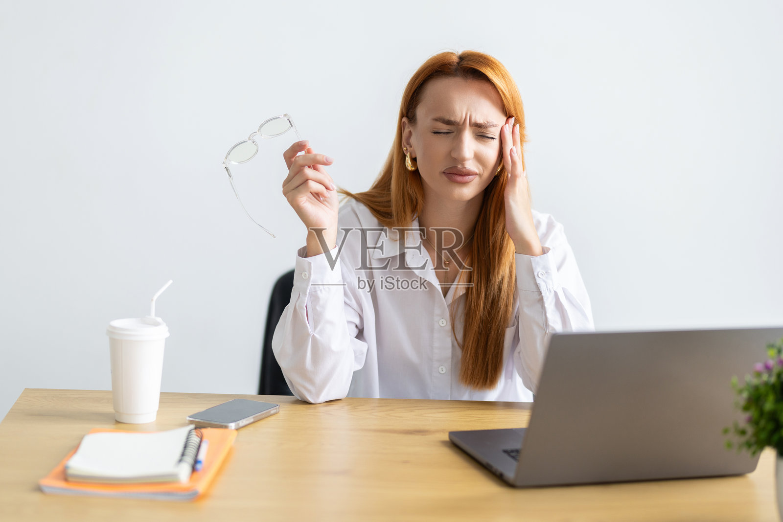 年轻女性在使用笔记本电脑时感到压力，疲惫的女商人在办公室头痛，工作时感到不适。照片摄影图片