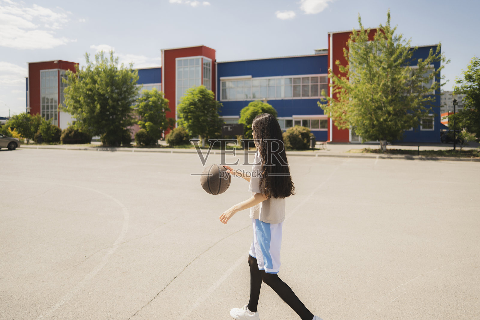 年轻女性在户外篮球场练习运球技巧照片摄影图片