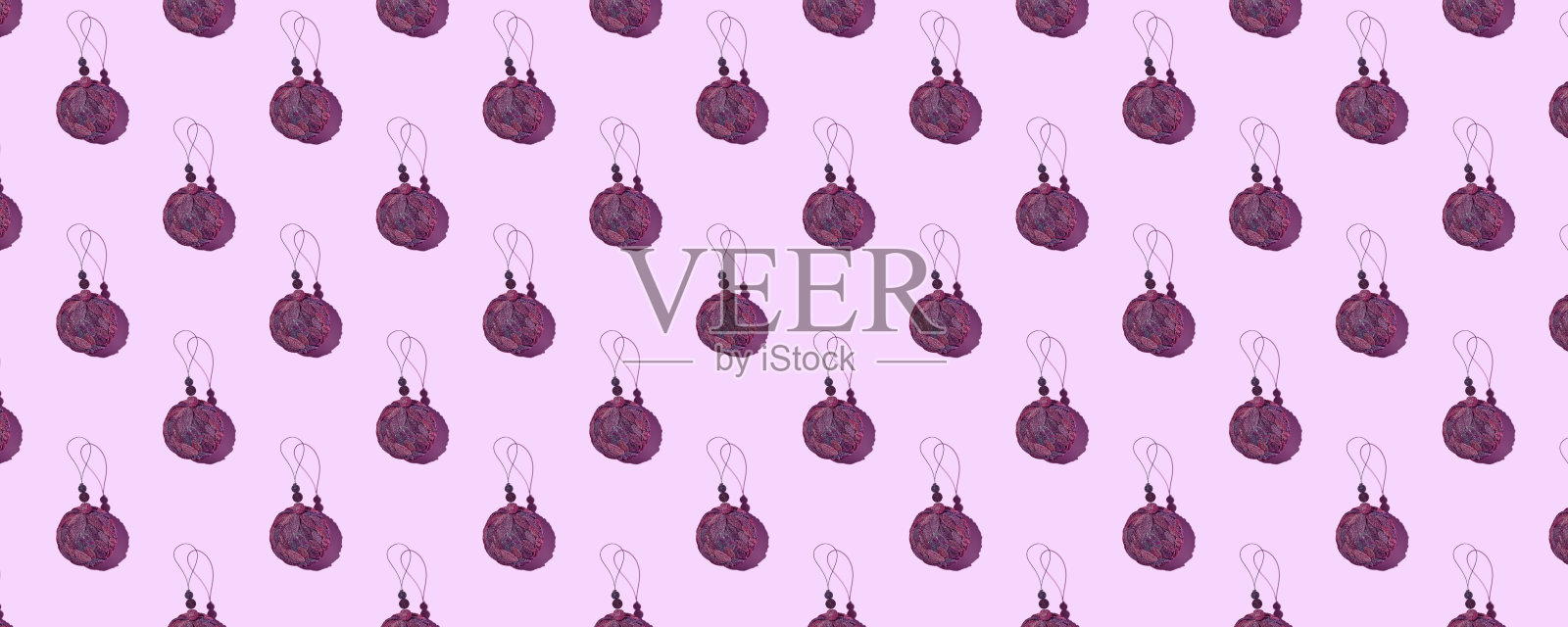 创意圣诞图案。紫色圣诞树球在紫罗兰色背景上的阴影。派对时光。圣诞贺卡。照片摄影图片