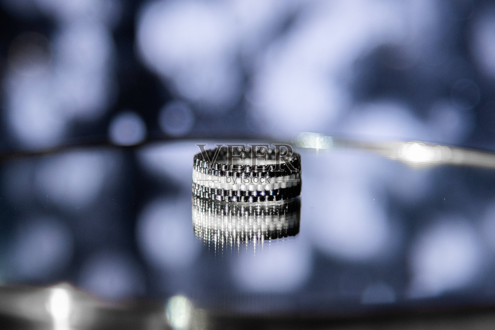 镜面背景上的珠子戒指照片摄影图片