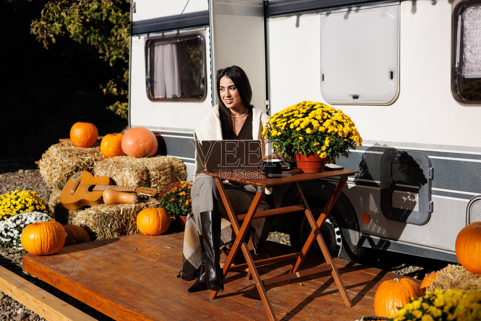 年轻女性在大自然中露营时，使用电脑上网。照片摄影图片