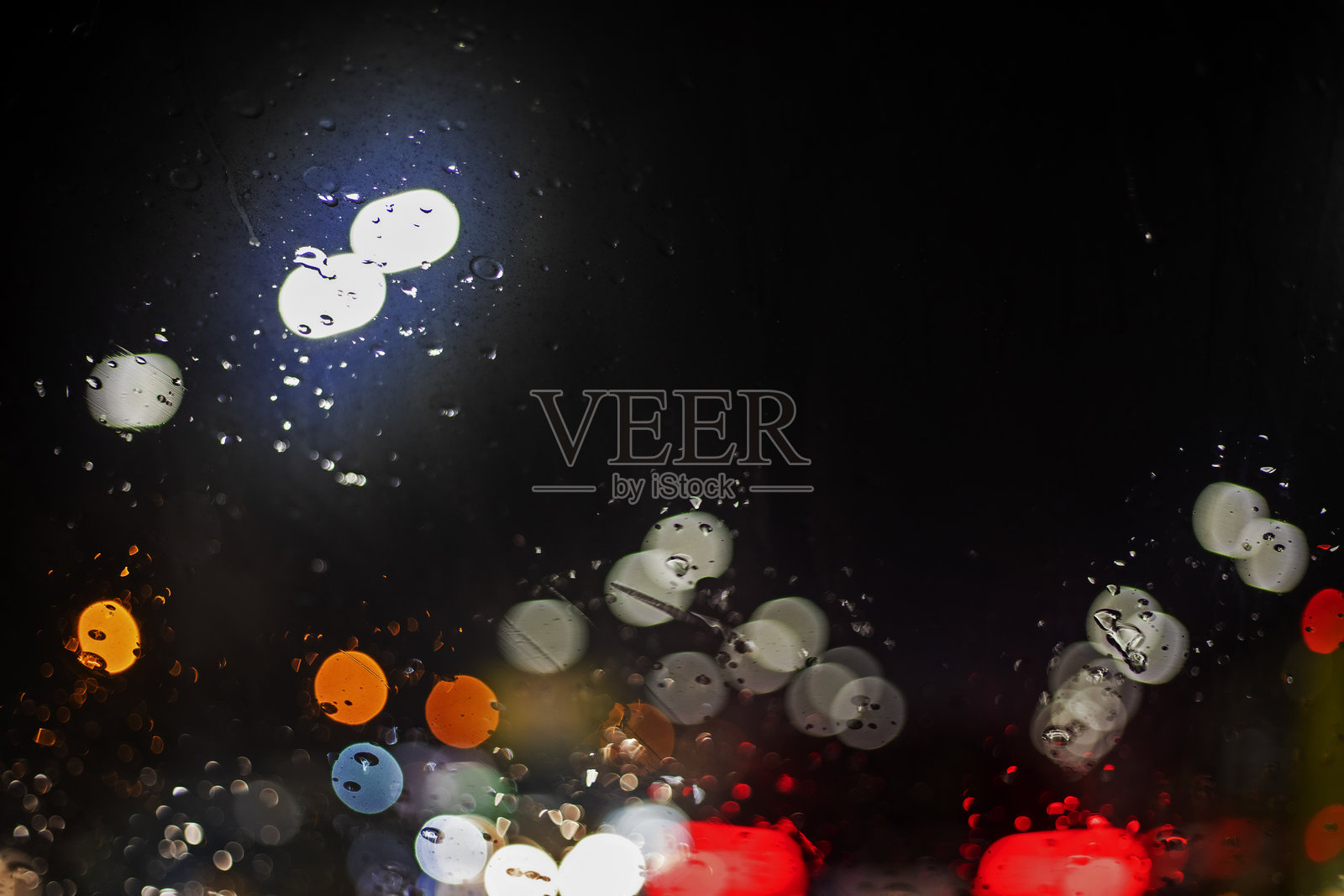 雨中汽车挡风玻璃反射的光线抽象背景。道路安全。能见度差。照片摄影图片