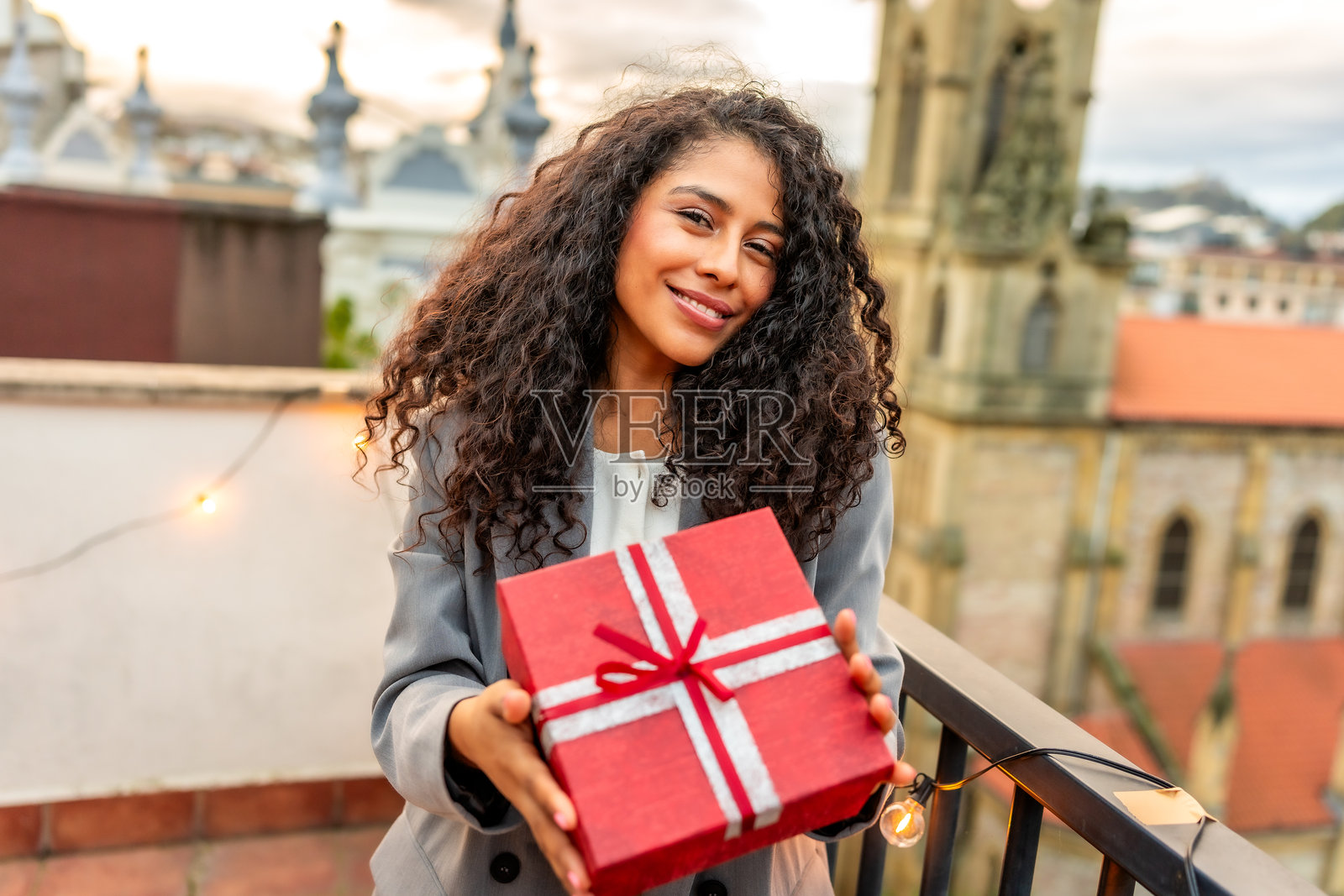 在屋顶上收到生日礼物的西班牙裔女性照片摄影图片