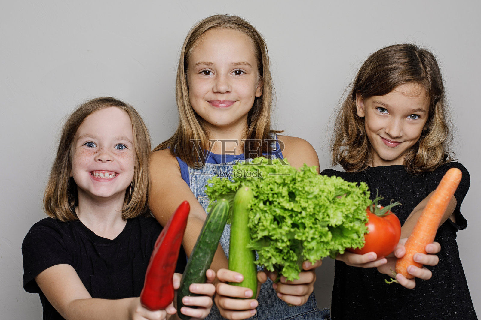 美丽的孩子们拿着蔬菜的肖像在白色的工作室墙壁横幅背景。童女以新鲜有机食品为画像，健康饮食理念照片摄影图片