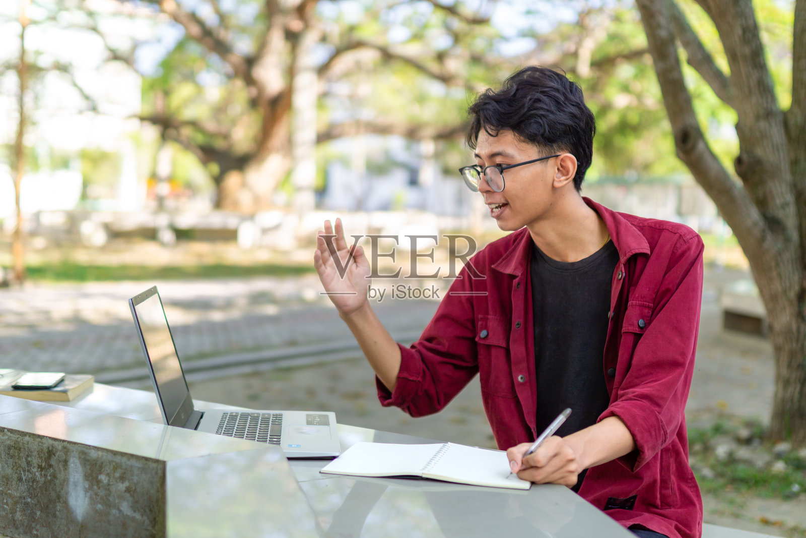 一个亚洲人正在用笔记本电脑进行视频通话。照片摄影图片