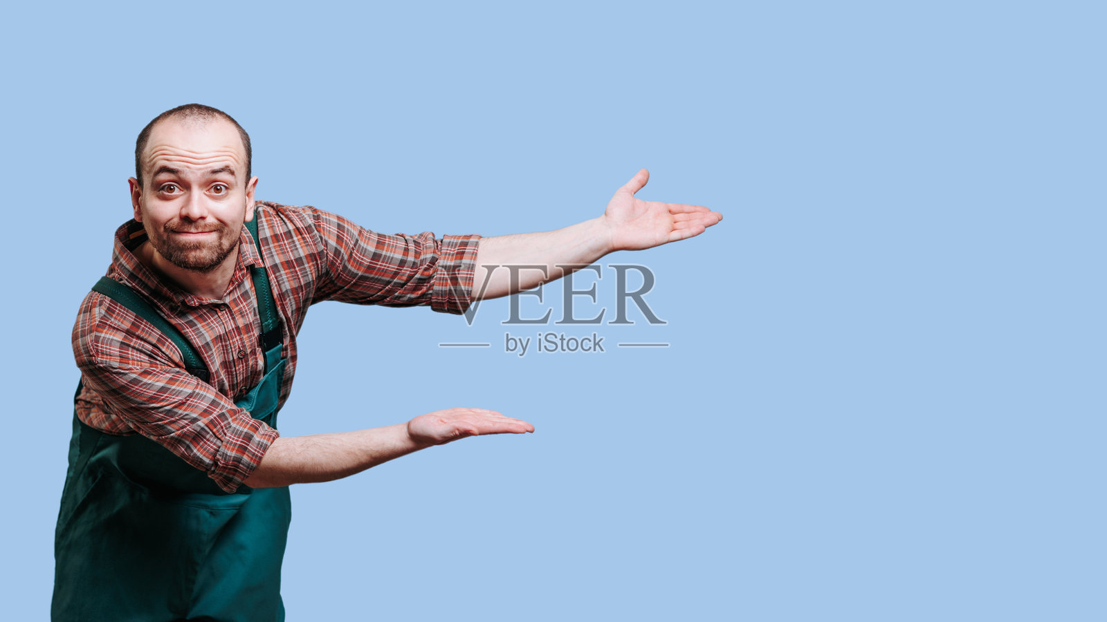 一名男子伸出双手专注地盯着镜头，脸上带着疑惑的表情照片摄影图片