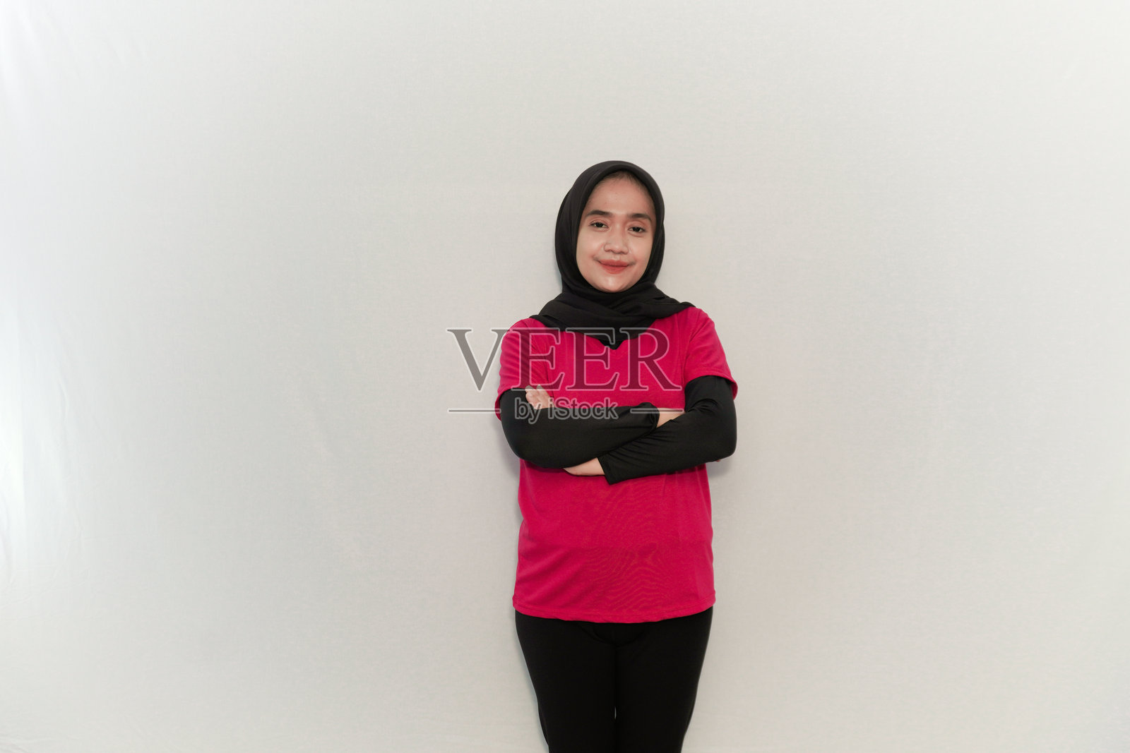 穿着红色头巾的女性正交叉双臂进行热身运动照片摄影图片