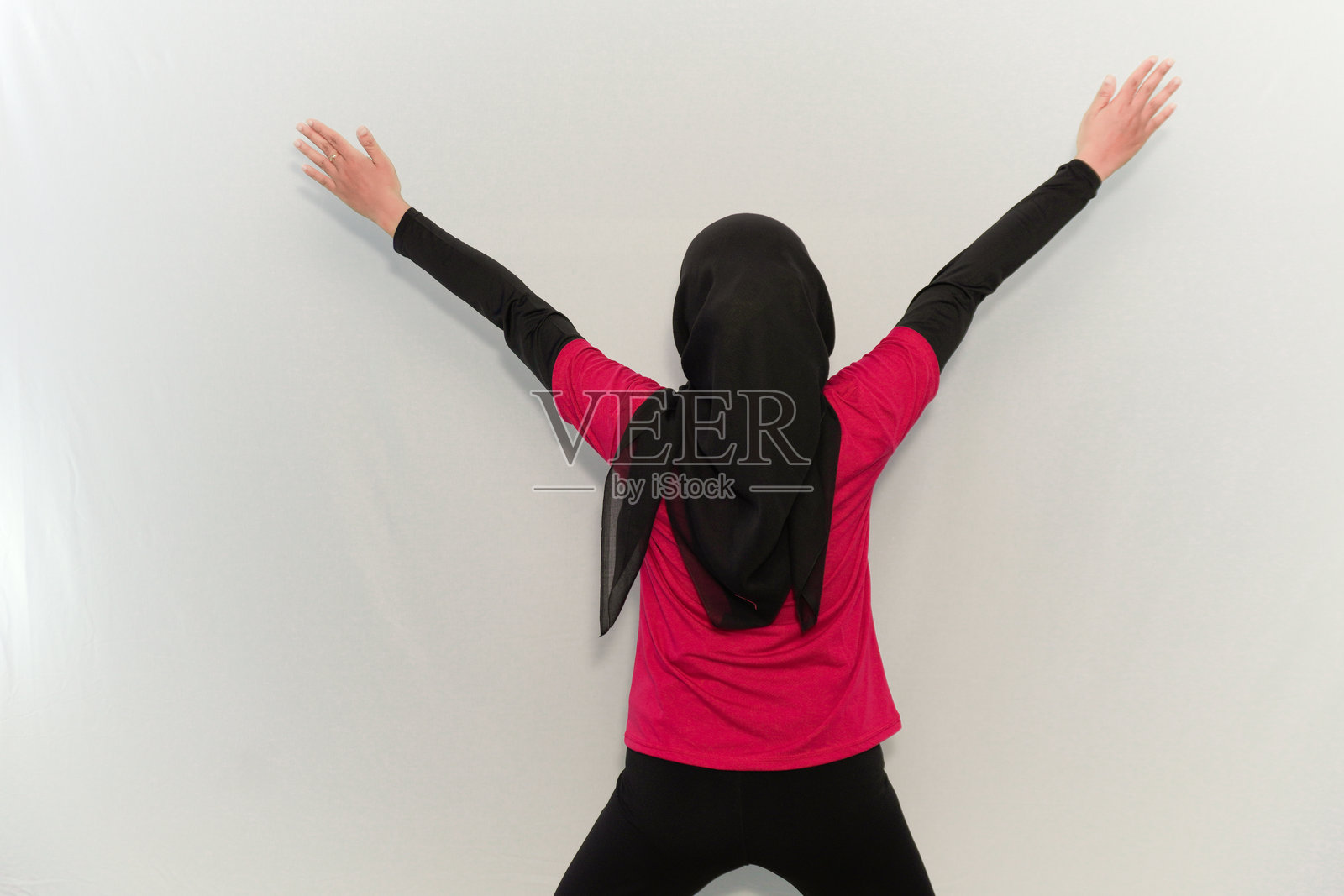 身穿红色头巾的女性从背后举起双手进行热身运动照片摄影图片