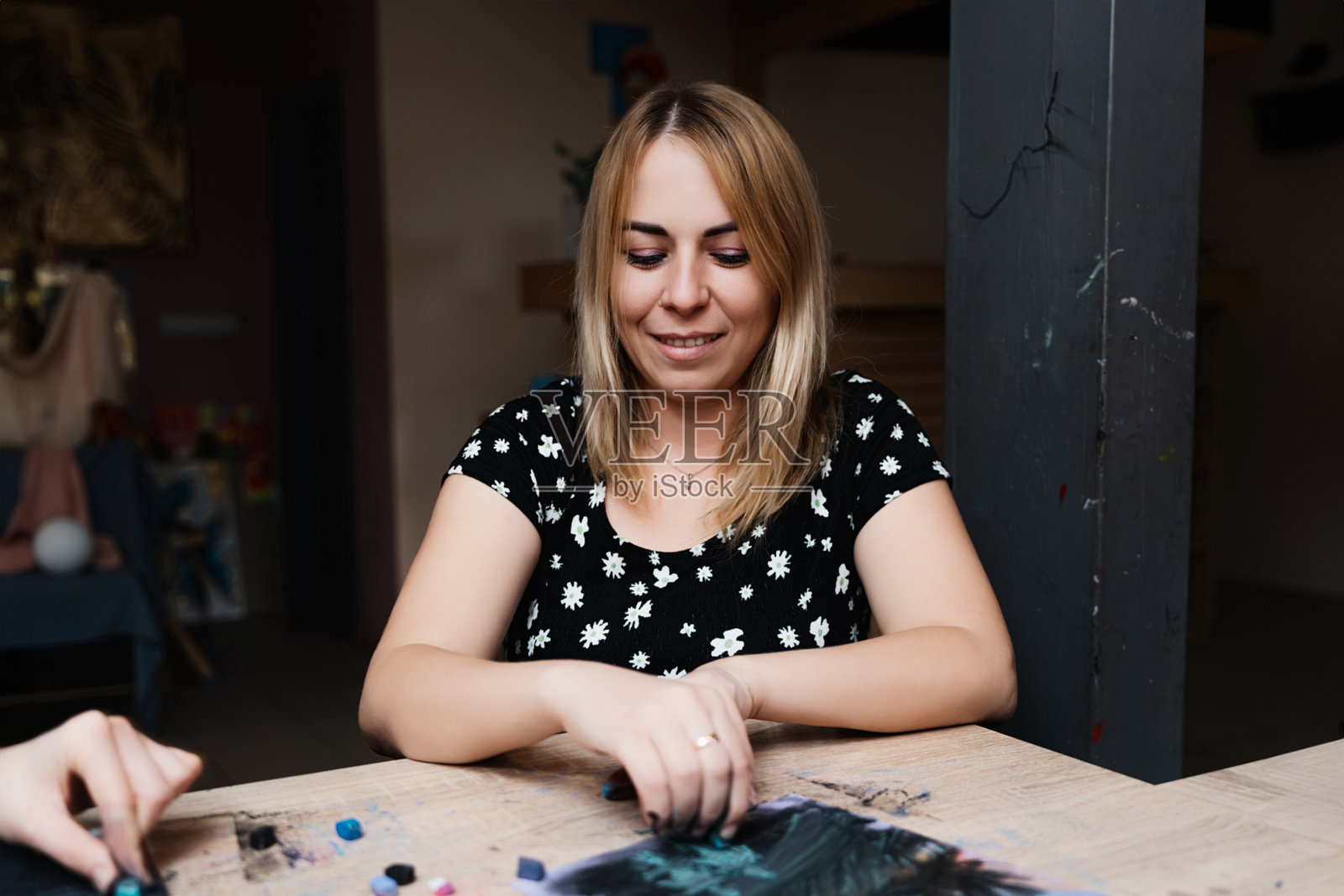 女性在明亮的工作室里用粉彩创作艺术作品，正值白天。照片摄影图片