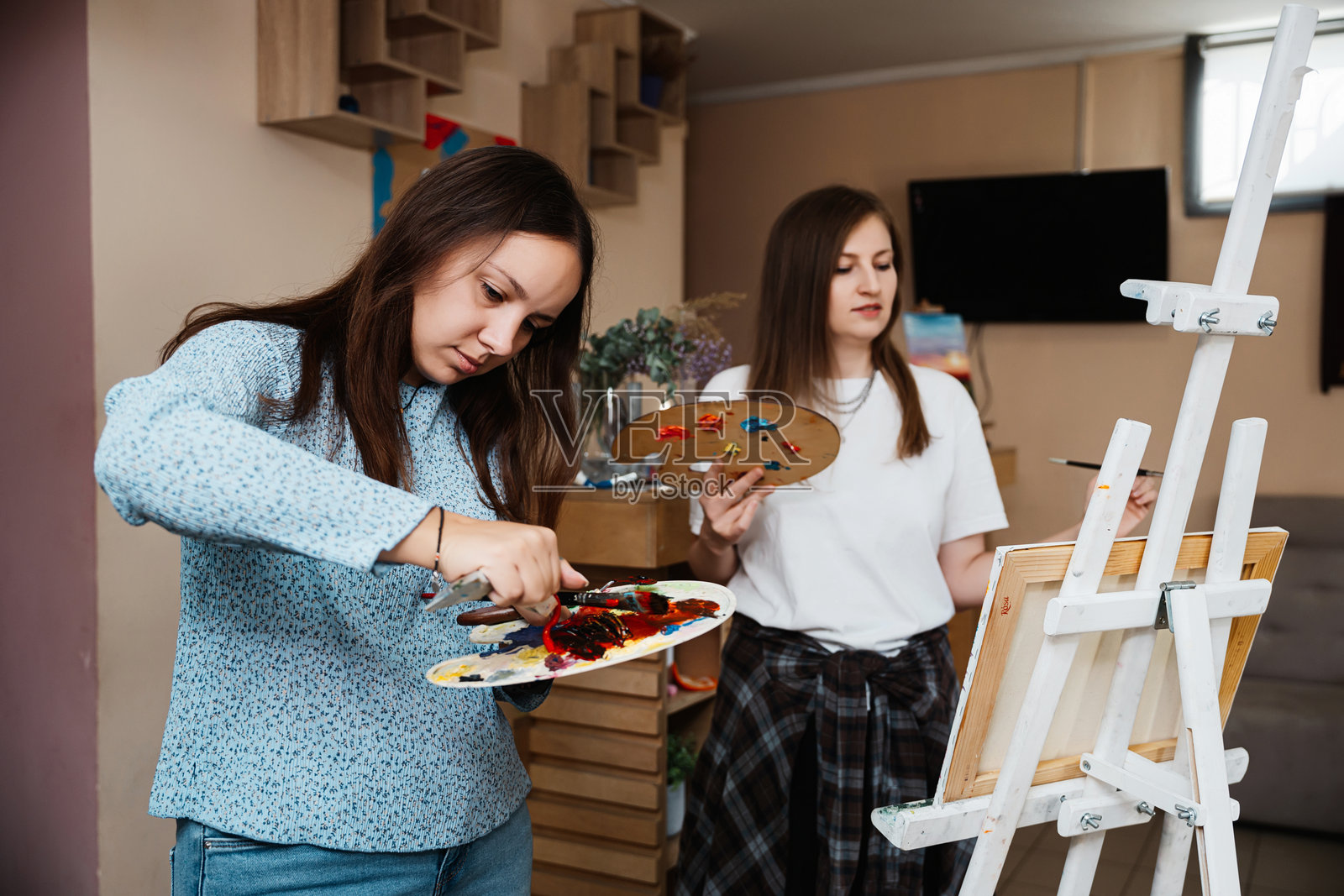 两位女性在白天的创意工作室里一起绘画照片摄影图片