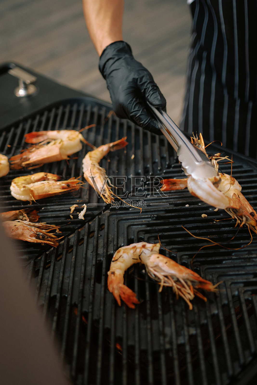 在厨房环境中进行烹饪准备时，烤制新鲜虾的概念照片摄影图片