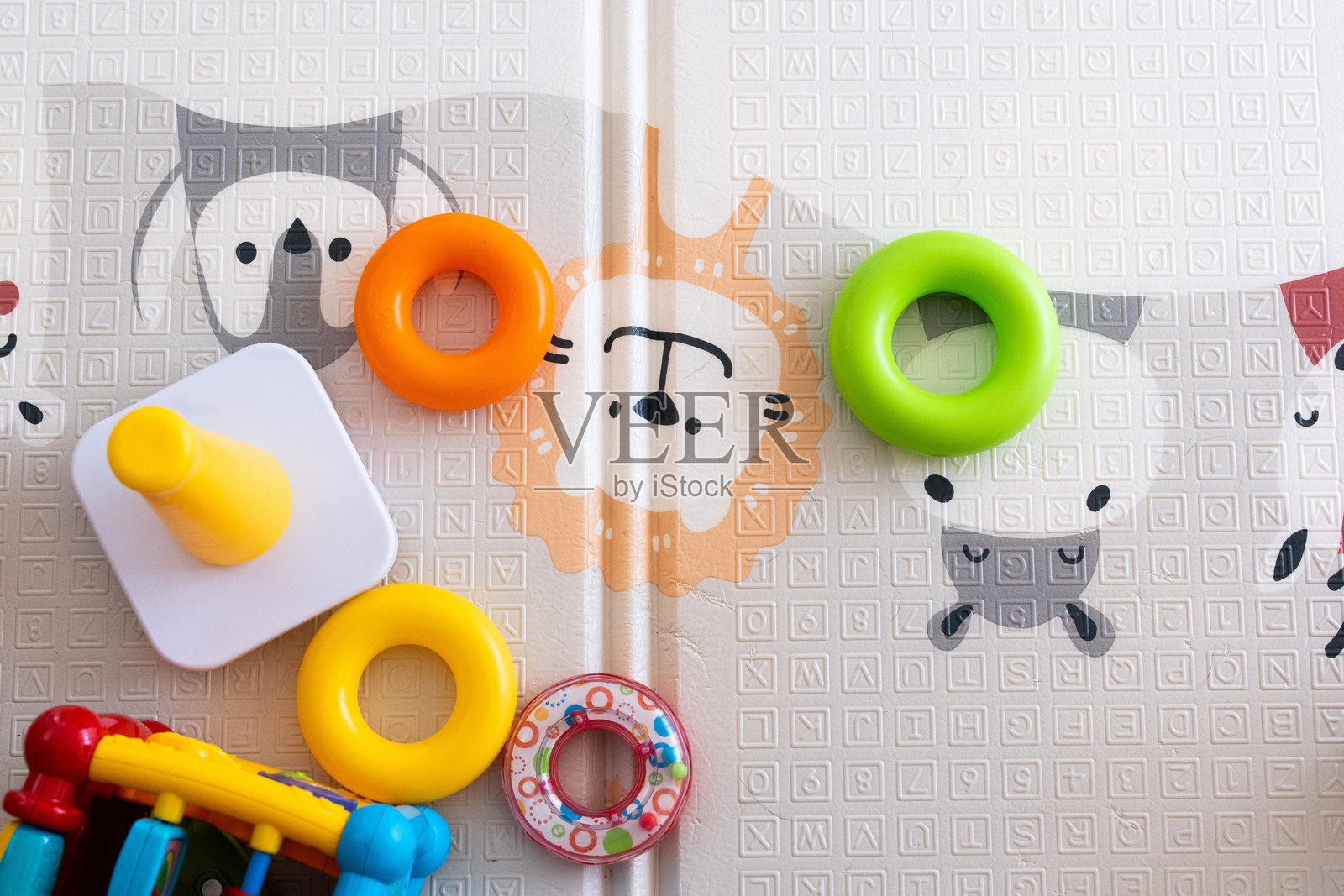 婴儿游戏垫的俯视图，上面有字母和各种婴儿玩具照片摄影图片