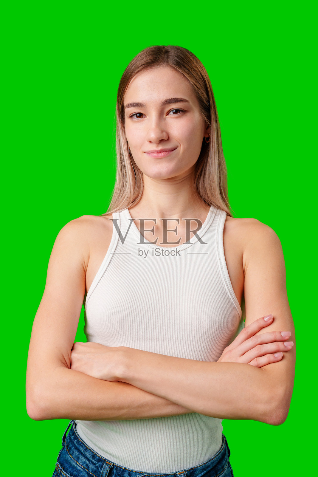 金发女子双臂交叉在绿幕前摆姿势照片摄影图片