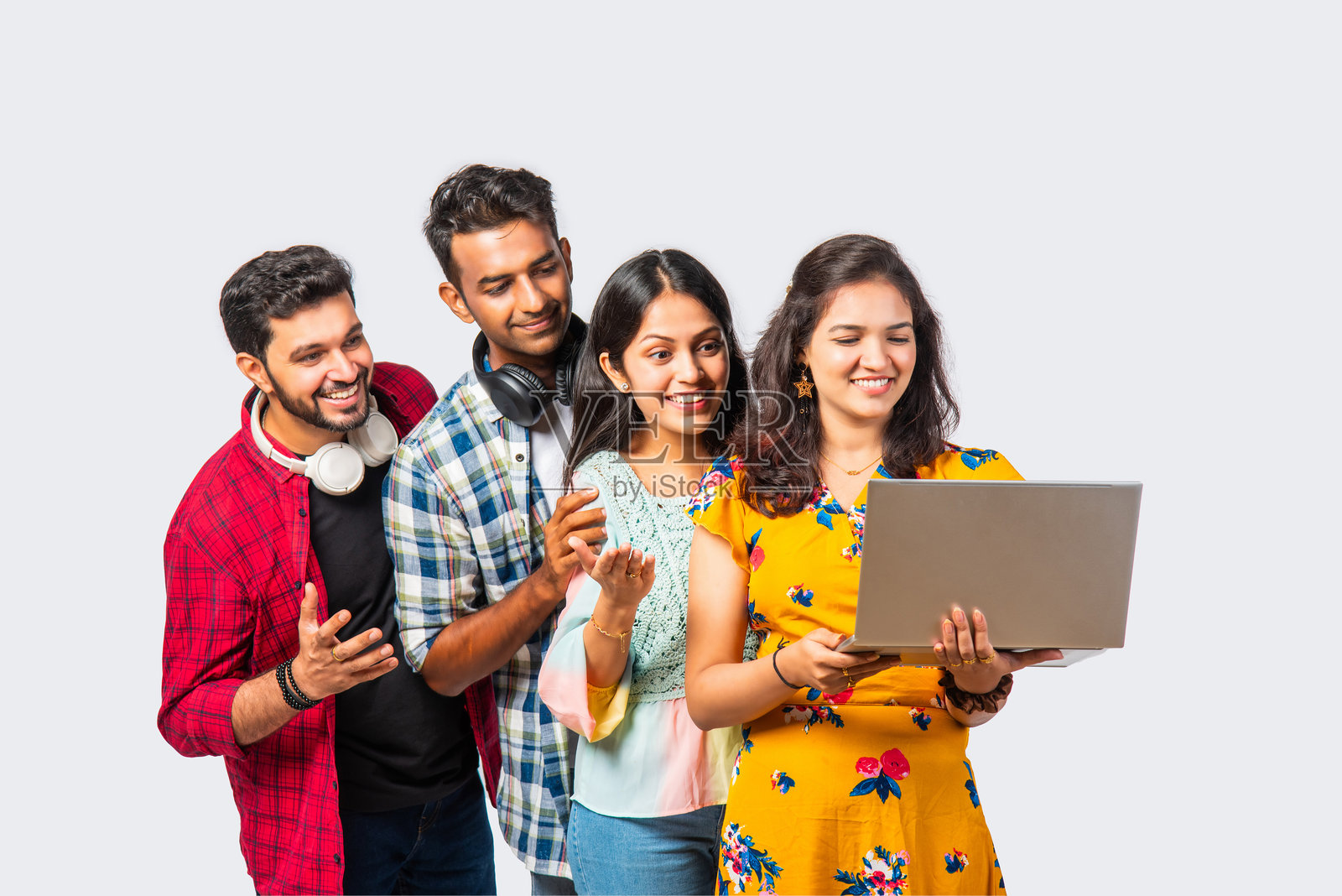 四个年轻的印度亚裔大学朋友带着背包，书，笔记本电脑，站在孤立的白色，在图书馆学习照片摄影图片