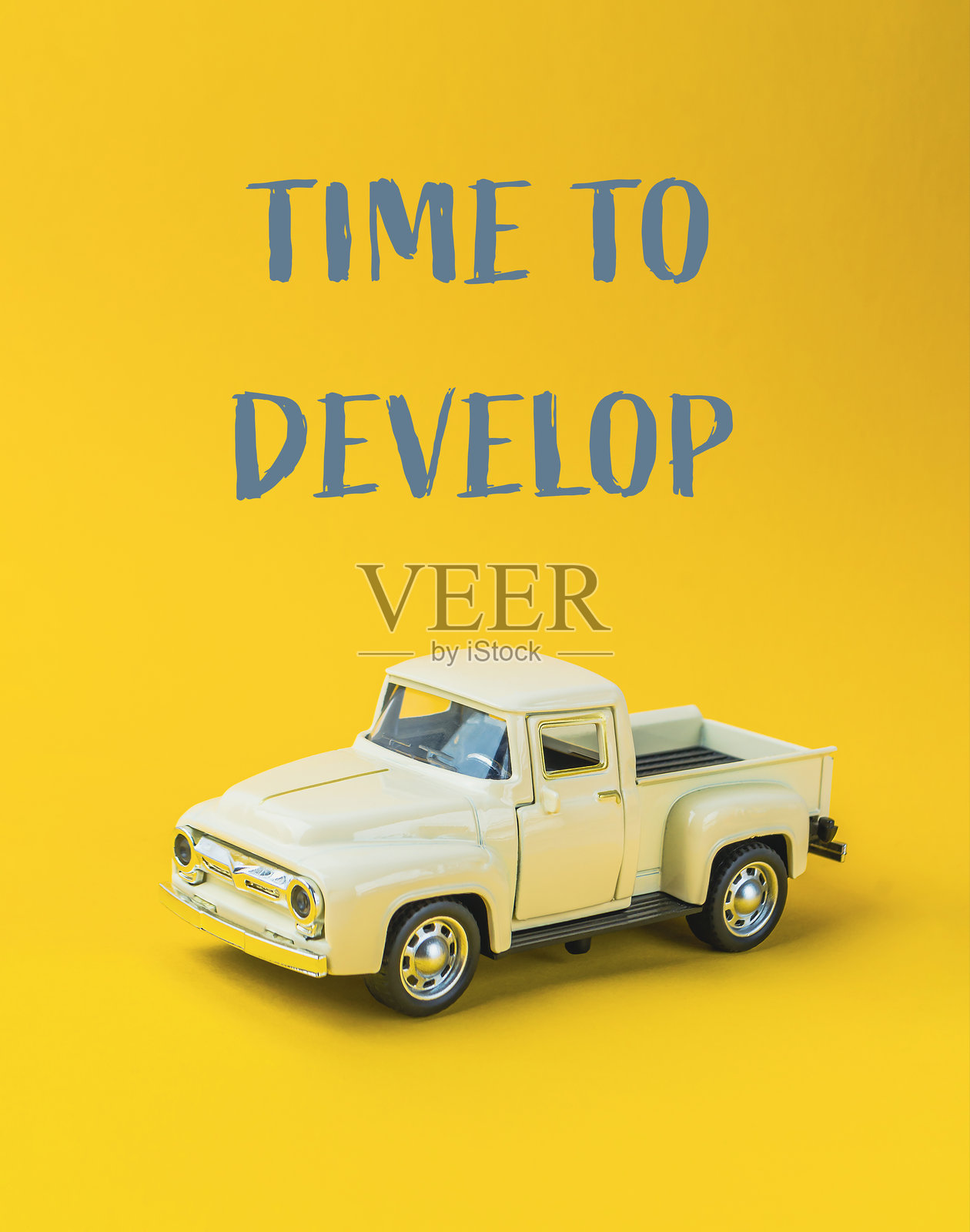 玩具卡车放在黄色背景上，旁边有“是时候发展了”的字样照片摄影图片