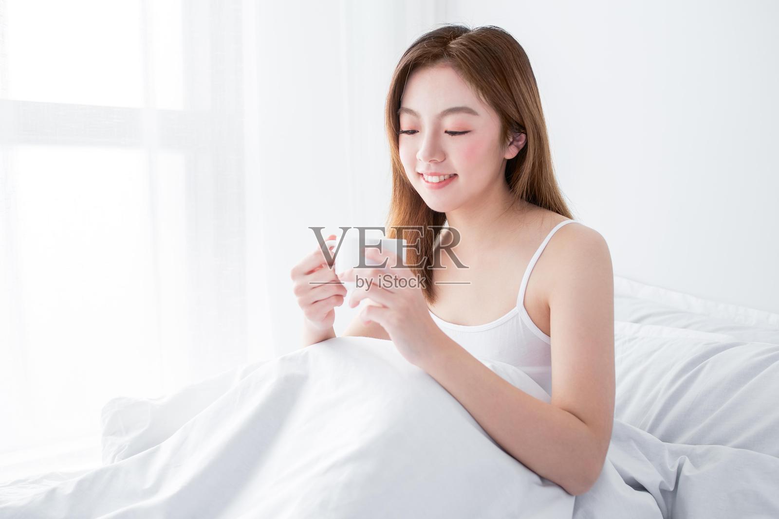 一位女性在床上喝咖啡照片摄影图片