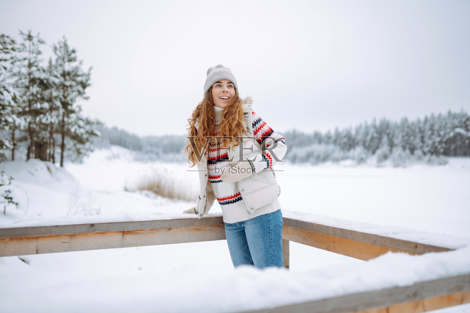 戴着帽子和围巾的快乐女性在户外享受冬日时光。自然、假期、休闲、旅行的概念。照片摄影图片