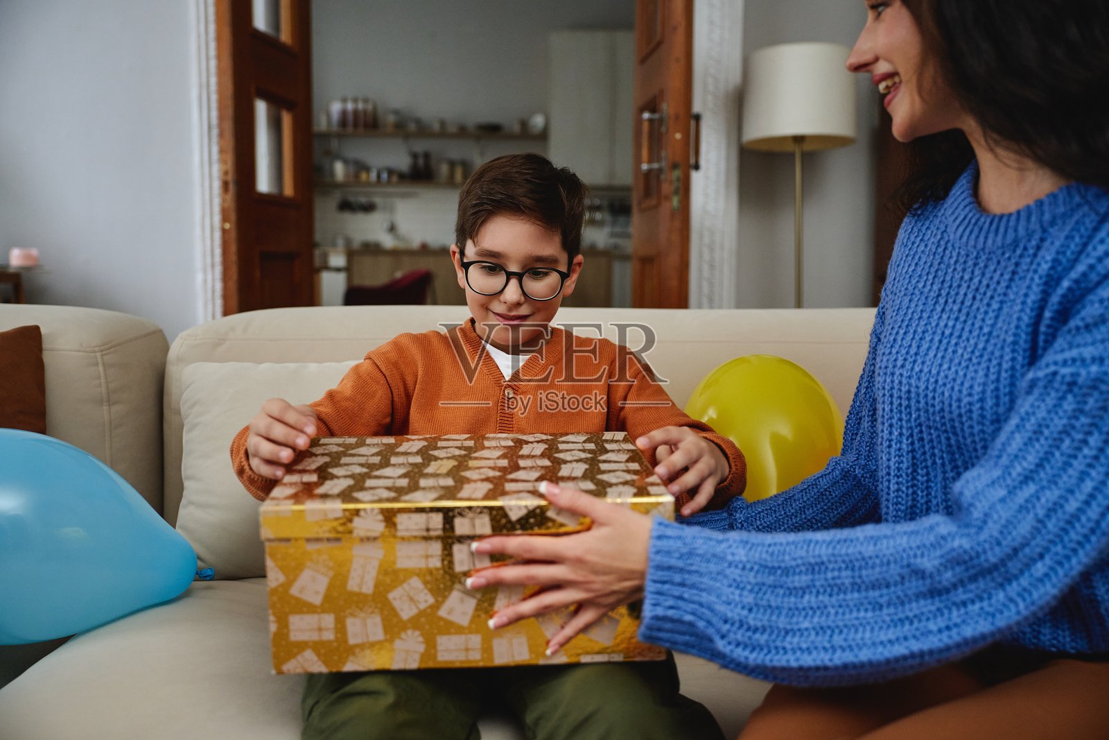 孩子在家庆祝时高兴地打开一个精美包装的礼物照片摄影图片