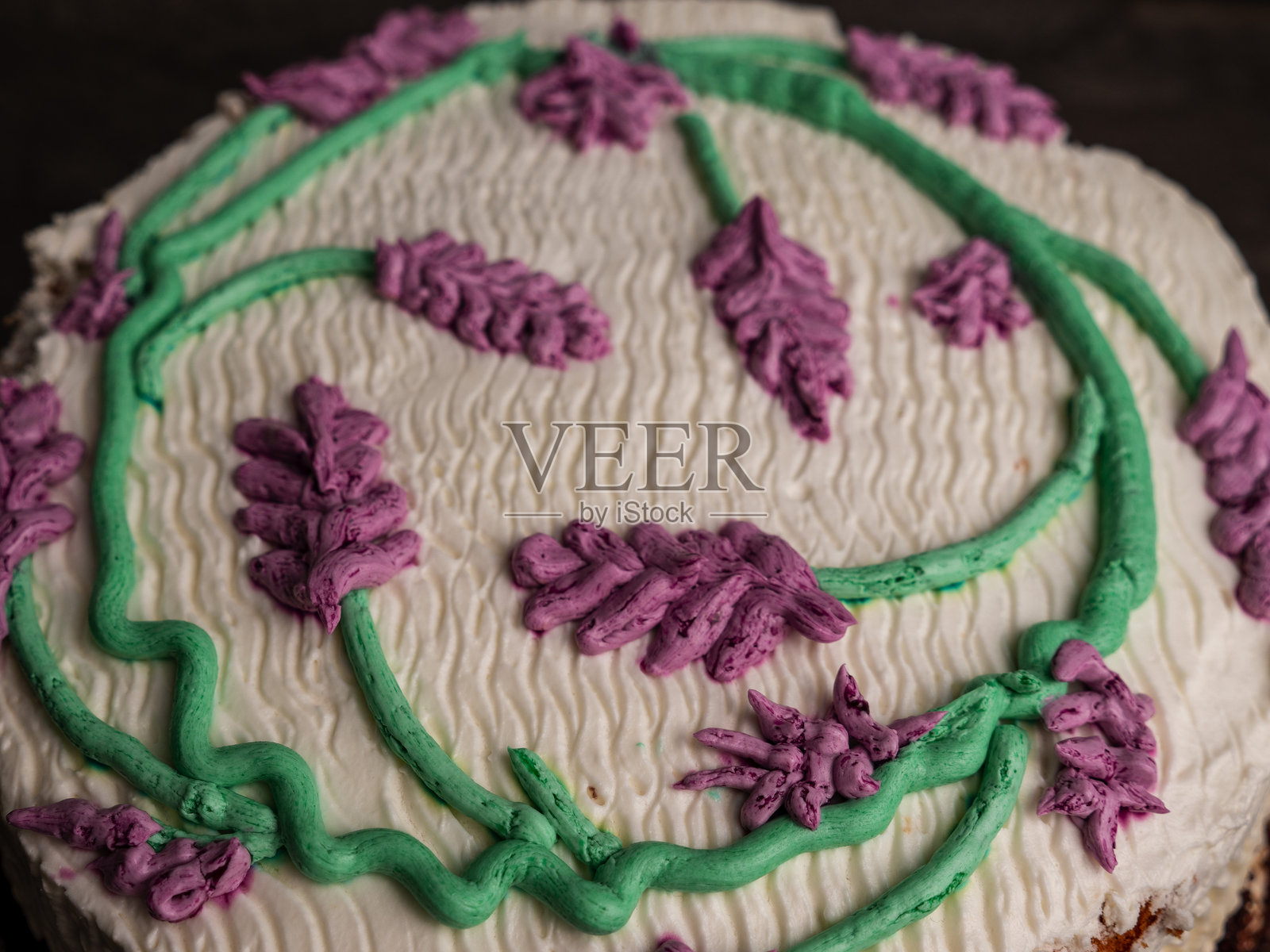 圆形蛋糕上装饰着花朵。蛋糕上有薰衣草。蛋糕上有奶油。照片摄影图片