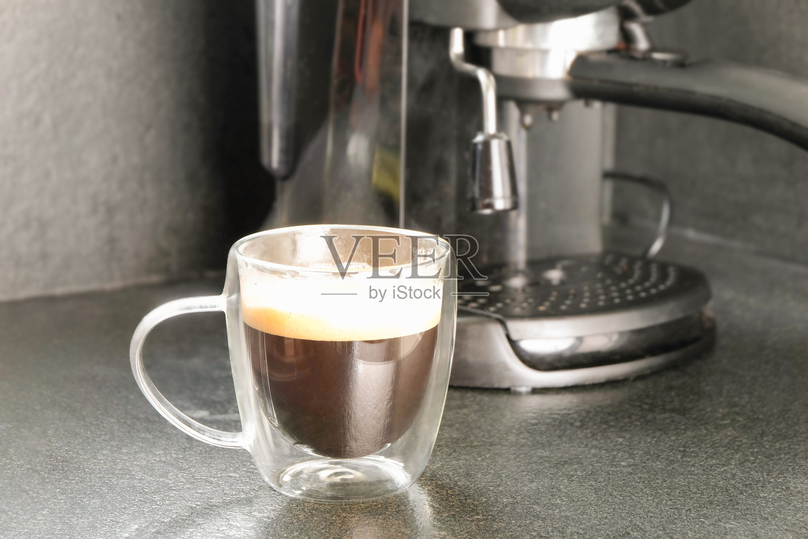 咖啡机上的咖啡杯，背景模糊照片摄影图片