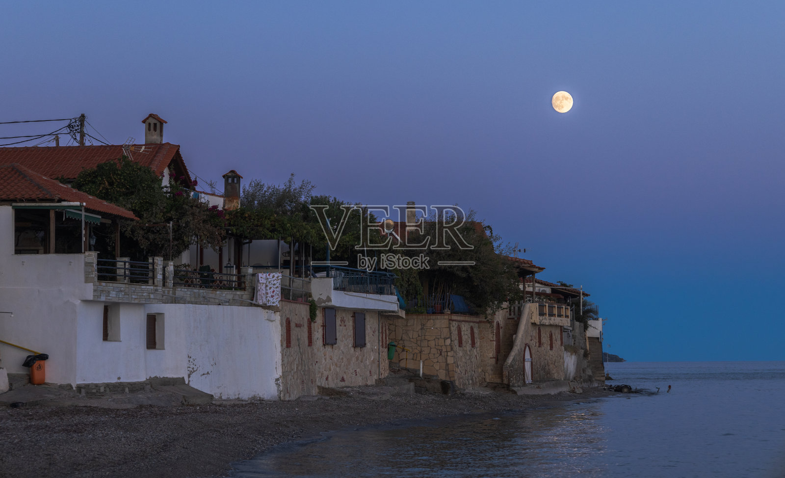 月光下的希腊海滨村庄，宁静的傍晚天空。照片摄影图片