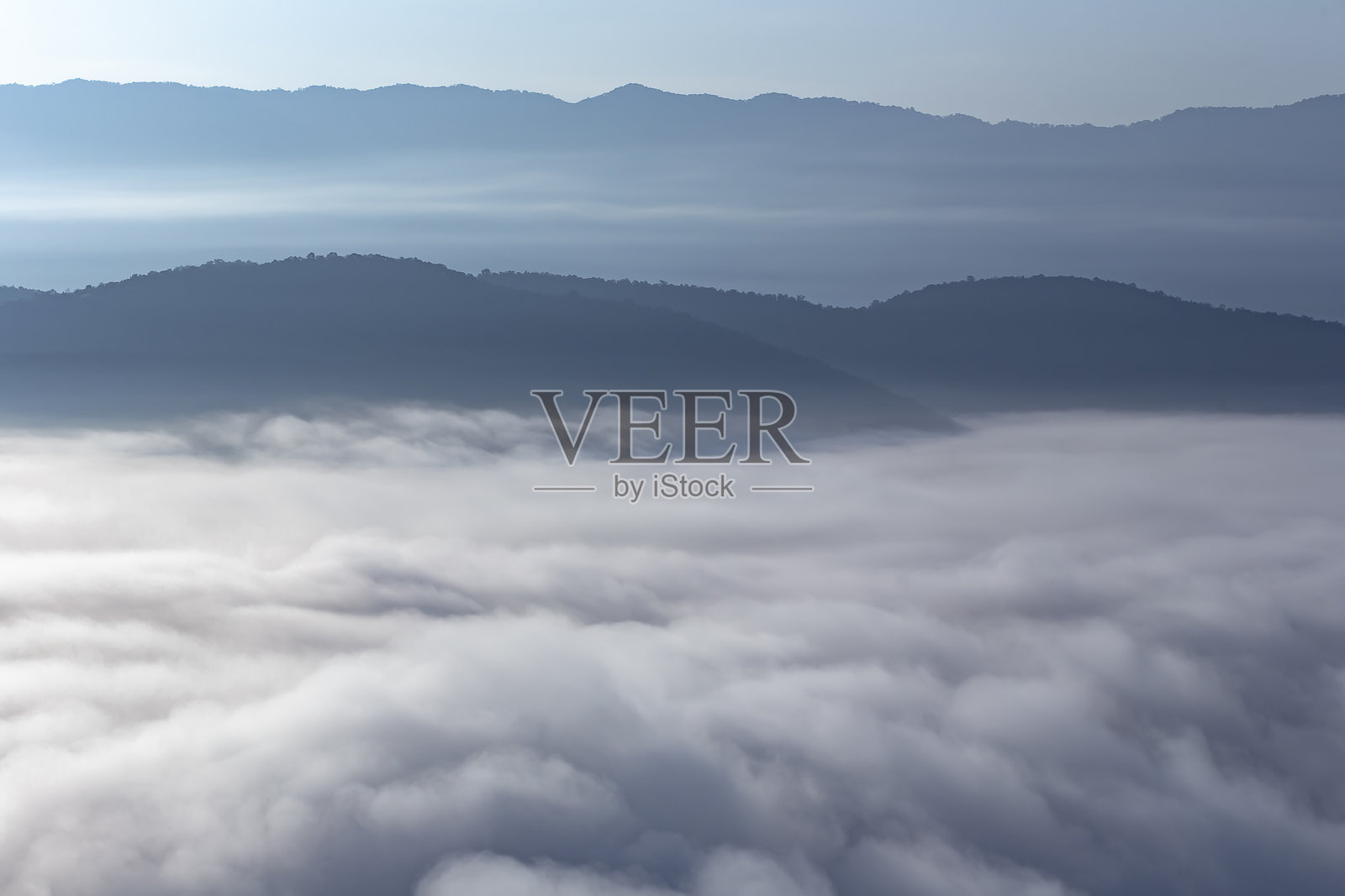 天气炎热潮湿，水汽弥漫，山谷前景形成了一片雾海。照片摄影图片