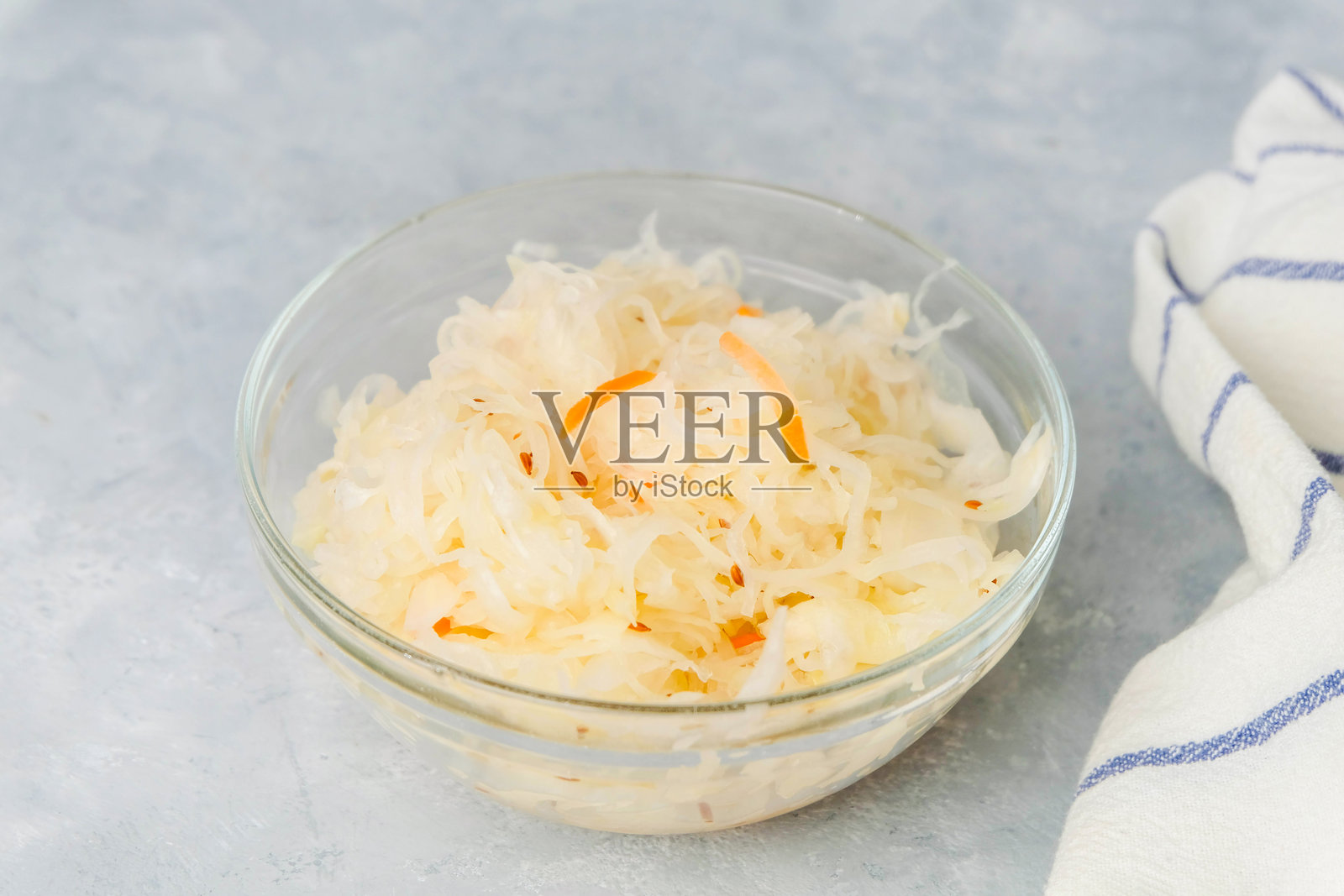 从上方看装有酸菜的盘子，背景为中性色调。发酵食品概念照片摄影图片