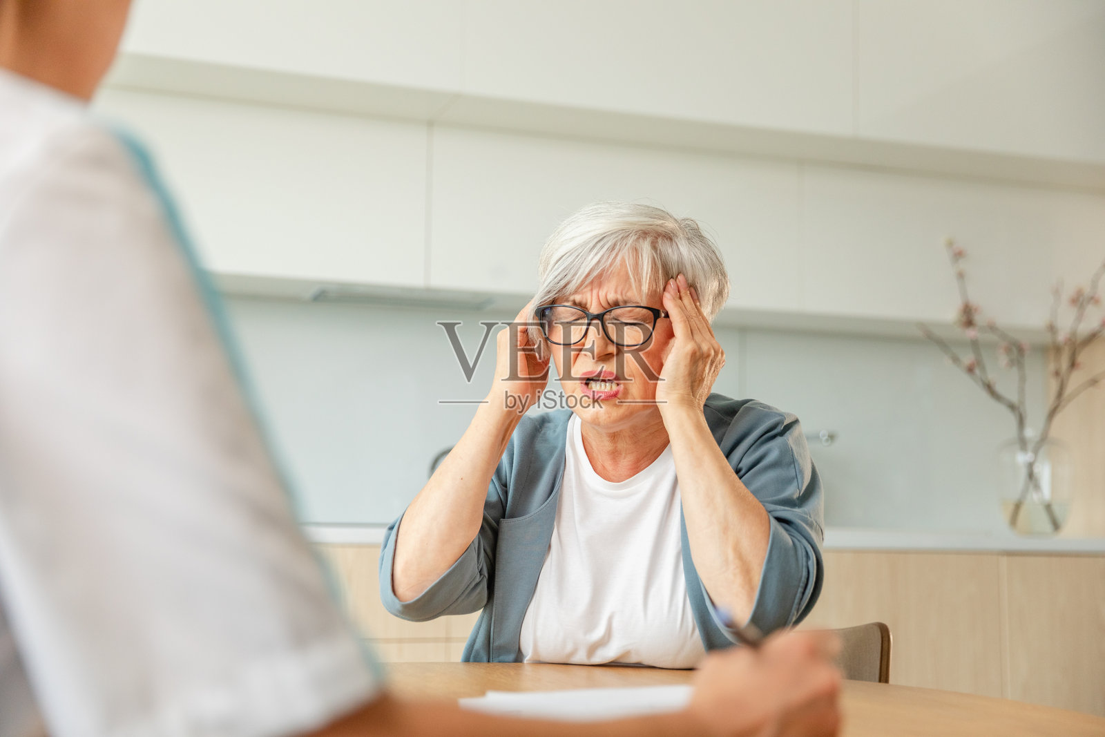 女医生在诊所或家中为年长女性进行检查。老年女性患者与医生在医院房间进行咨询。医疗保健体检。看医生。照片摄影图片