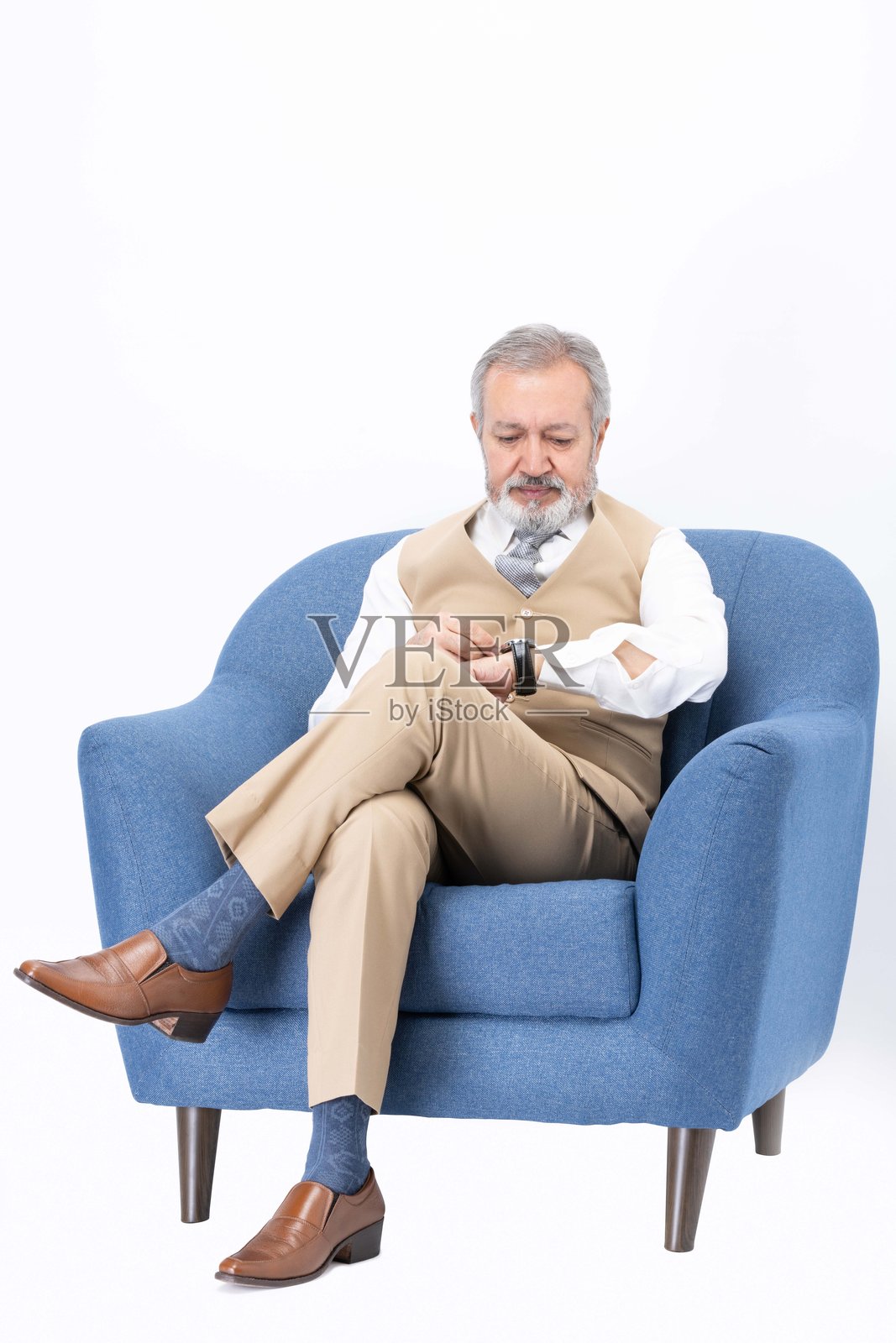 快乐的老年男子坐在沙发上，背景为白色照片摄影图片