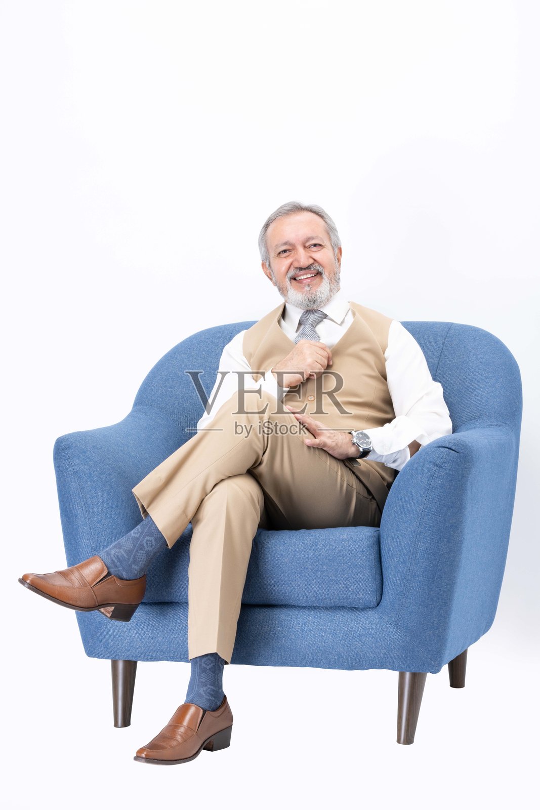 快乐的老年男子坐在沙发上，背景为白色照片摄影图片