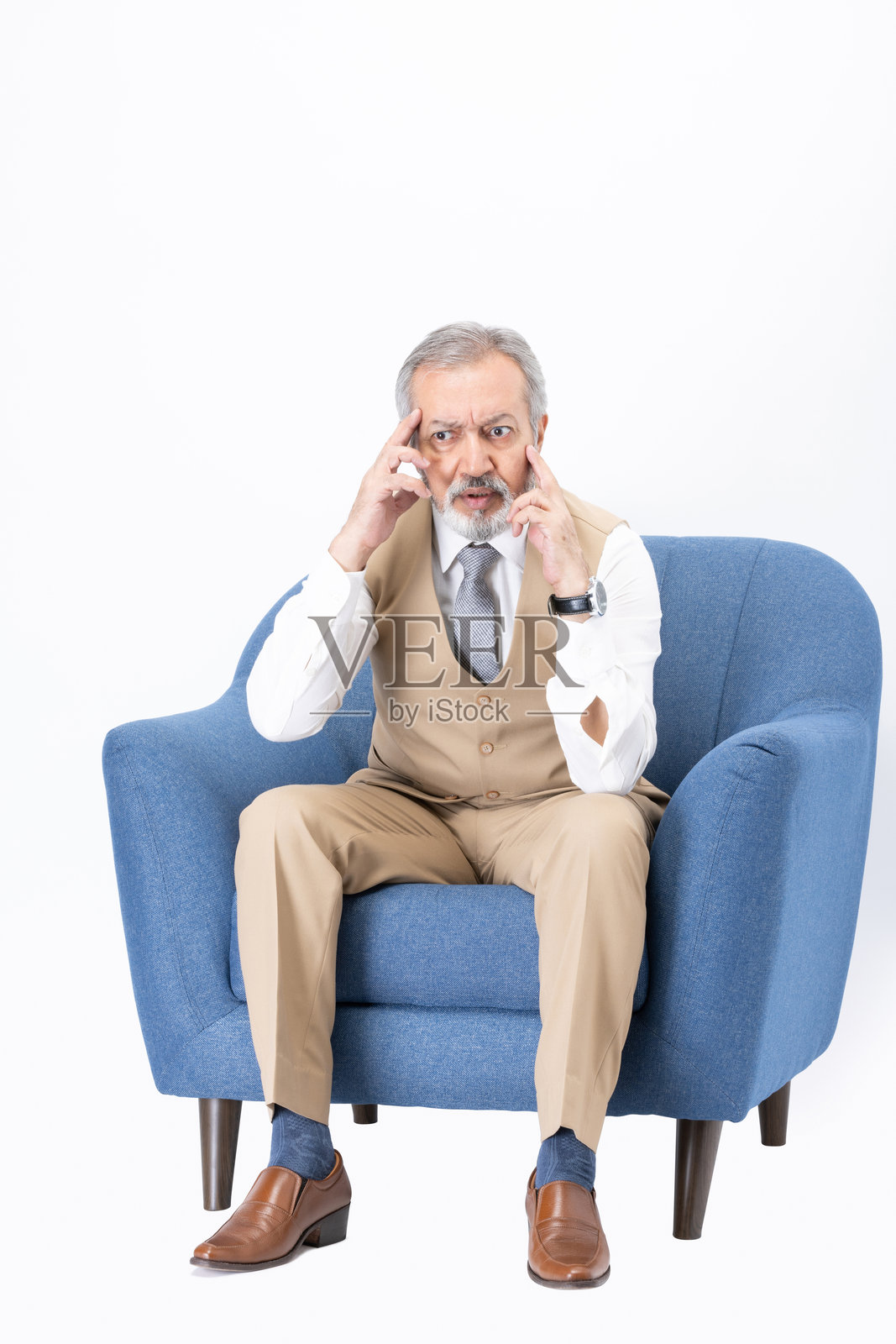 快乐的老年男子坐在沙发上，背景为白色照片摄影图片