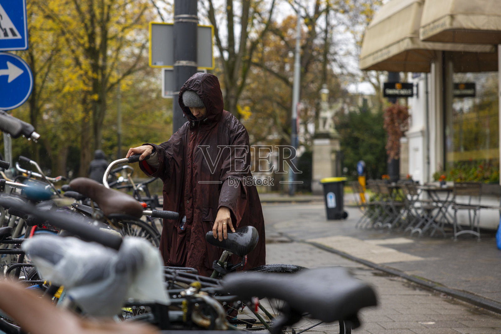 一位女性在雨中骑自行车照片摄影图片