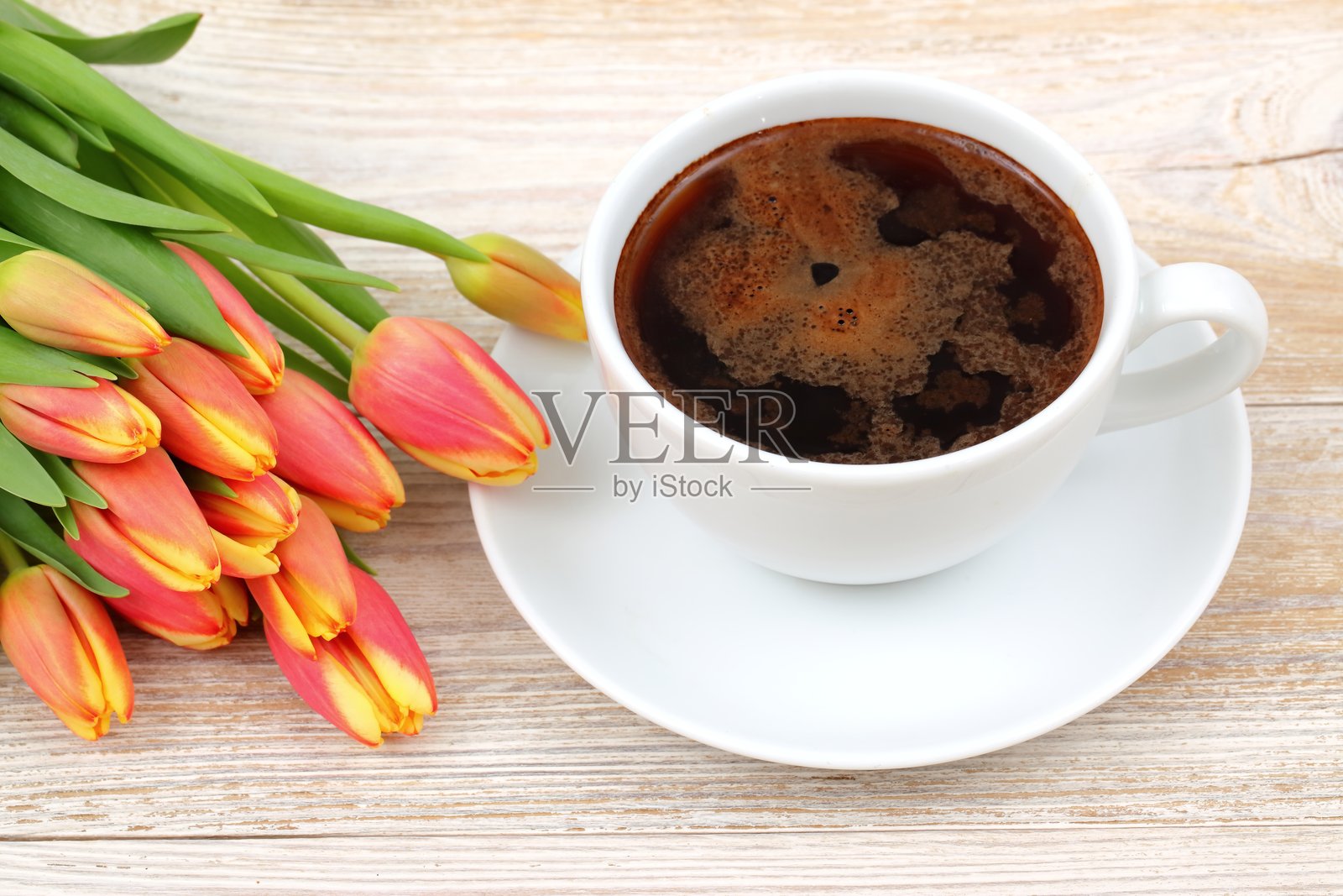 咖啡和美丽的郁金香为您的一天创造了完美的早晨氛围。照片摄影图片