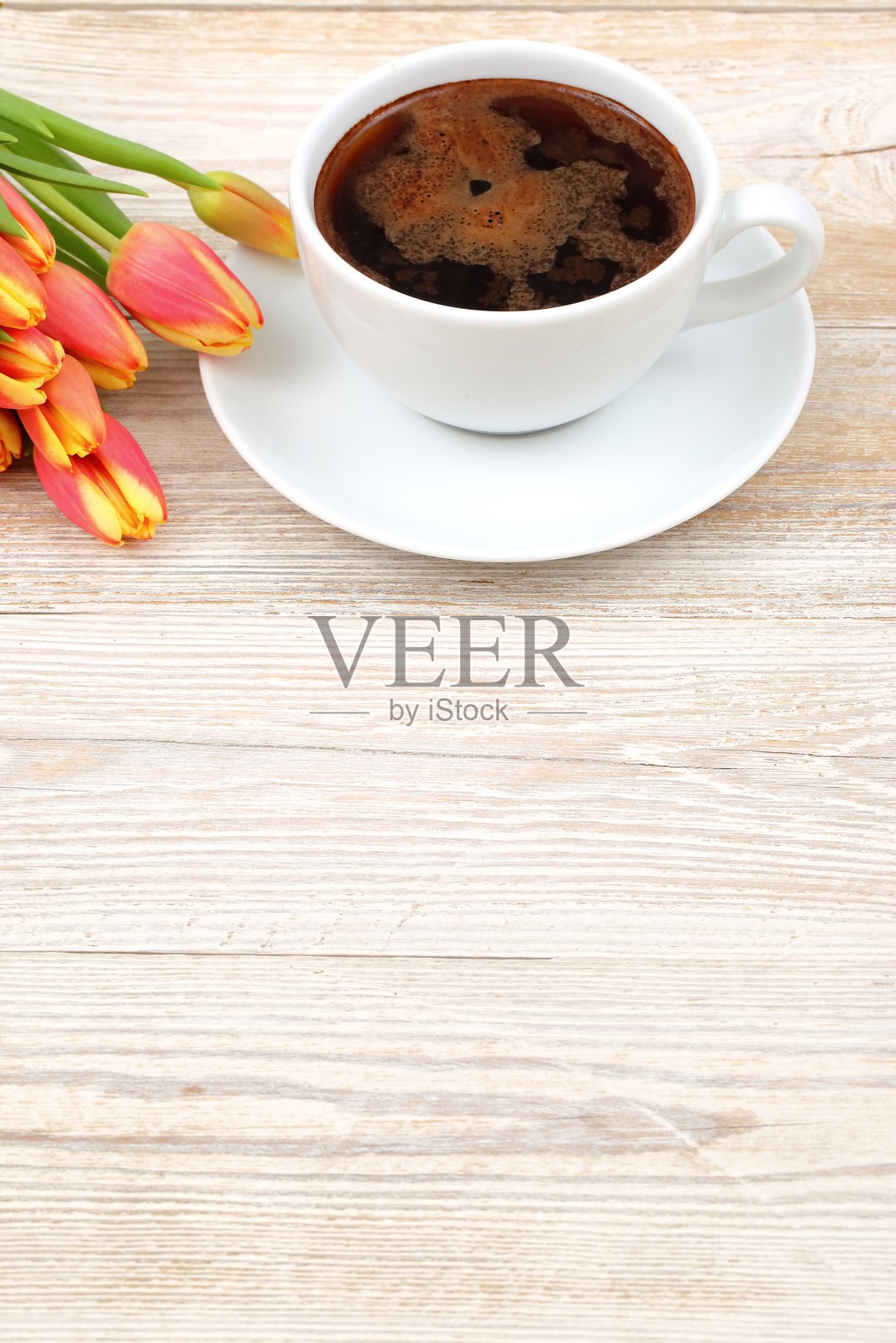 在质朴的木桌上美丽地摆放着咖啡和郁金香，散发出温暖和魅力。照片摄影图片