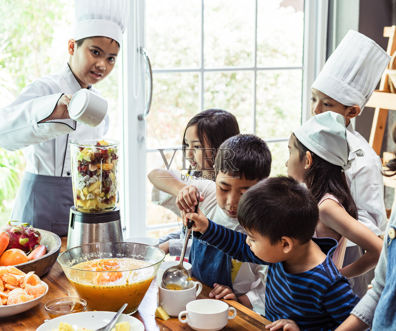 儿童学生和朋友们在学校课堂上学习烹饪。照片摄影图片